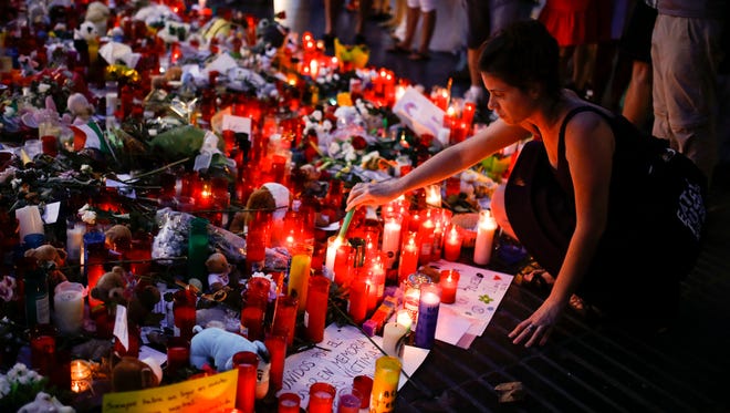 People display flowers, messages and candles to pay tribute to the victims of the Barcelona and Cambrils attacks on the Rambla boulevard in Barcelona on Aug. 22, 2017, one week after a van plowed into the crowd, killing 15 people and injuring over 100.