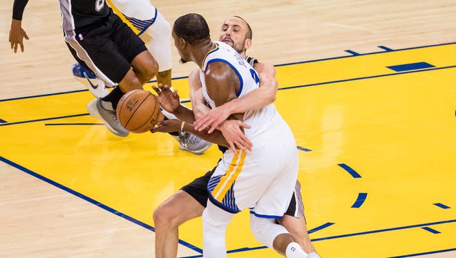 San Antonio Spurs guard Manu Ginobili wraps up Golden State Warriors forward Kevin Durant during the second quarter in Game 1 of the Western Conference finals.