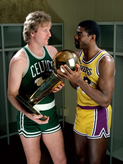 Larry Bird #33 of the Boston Celtics poses for a portrait with Magic Johnson of the Los Angeles Lakers with each holding the NBA Championship Trophy at The Great Western Forum in Los Angeles, California.