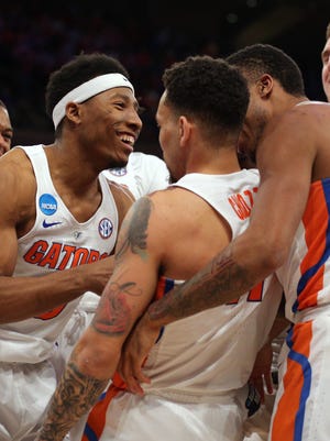 The Florida Gators celebrate with guard Chris Chiozza (11) after he hit the game winning the shot to beat the Wisconsin Badgers during overtime in the semifinals of the East Regional of the 2017 NCAA tournament at Madison Square Garden.