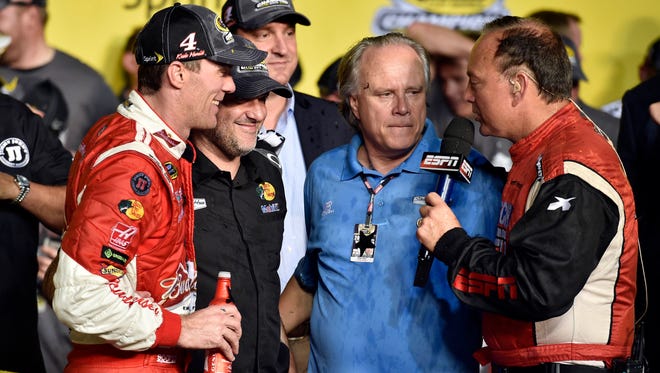 Kevin Harvick, left, and team co-owners Tony Stewart, second from left, and Gene Haas, second from right, do an interview with ESPN in victory lane at Homestead-Miami Speedway.