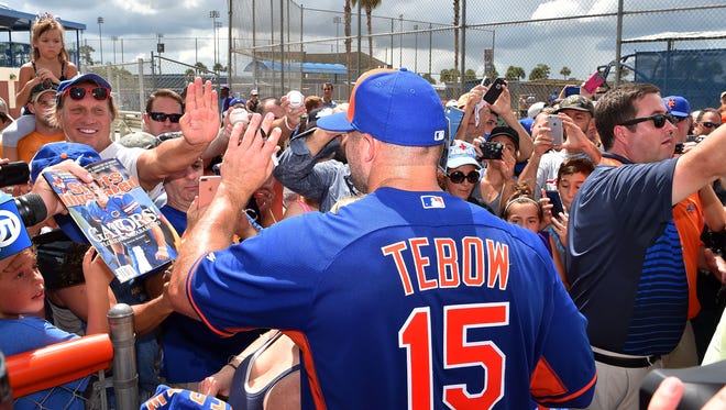 Sept. 19: Tim Tebow greets the fans after his workout.