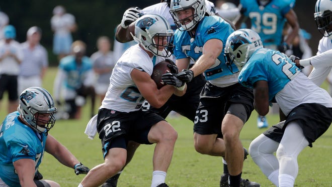 Carolina Panthers rookie Christian McCaffrey (22) runs as Ben Jacobs (53) defends during practice at the NFL team's football training camp at Wofford College in Spartanburg, S.C., Thursday, Aug. 3, 2017.