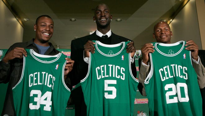 Newly-acquired Boston Celtics forward Kevin Garnett, center, stands with forward Paul Pierce, left, and guard Ray Allen during a news conference in Boston.