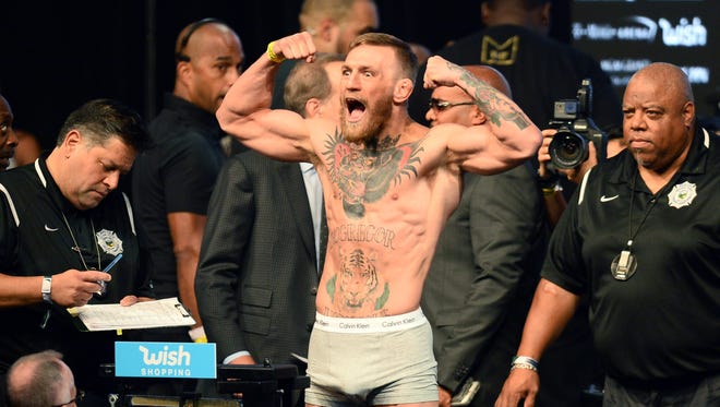 Conor McGregor weighs in for his upcoming boxing match against Floyd Mayweather Jr. (not pictured) at T-Mobile Arena.