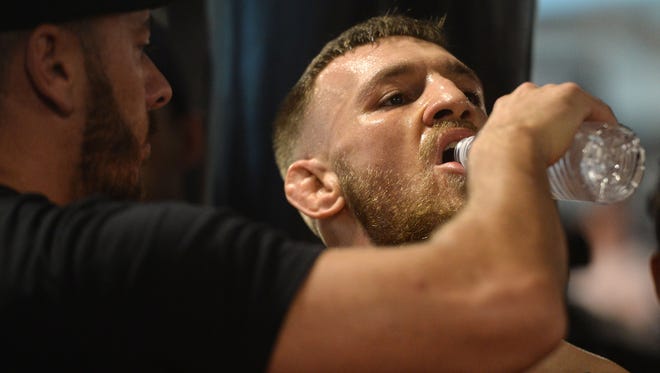 Conor McGregor drinks water during a media workout in preparation for his fight against Floyd Mayweather at UFC Performance Institute.