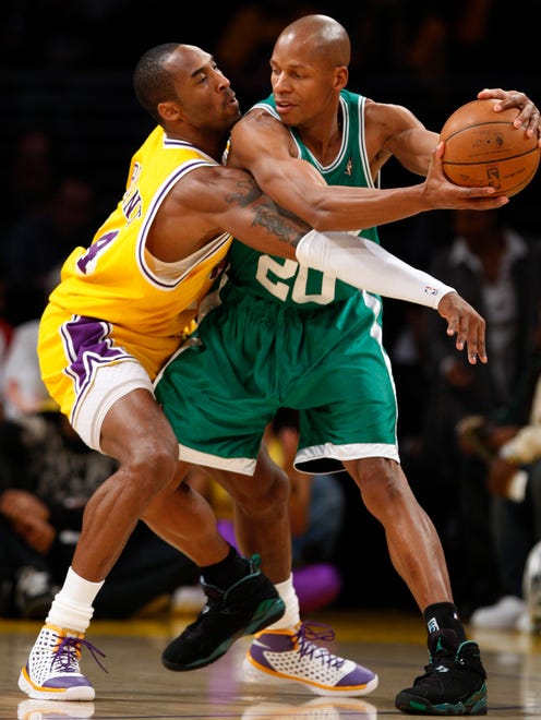 Kobe Bryant tries to swat the ball away from the Celtics' Ray Allen during 1st half action at Staples Center.