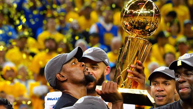 Golden State Warriors forward Kevin Durant (35) celebrates with the Larry O'Brien Trophy after beating the Cleveland Cavaliers in game five of the 2017 NBA Finals at Oracle Arena.