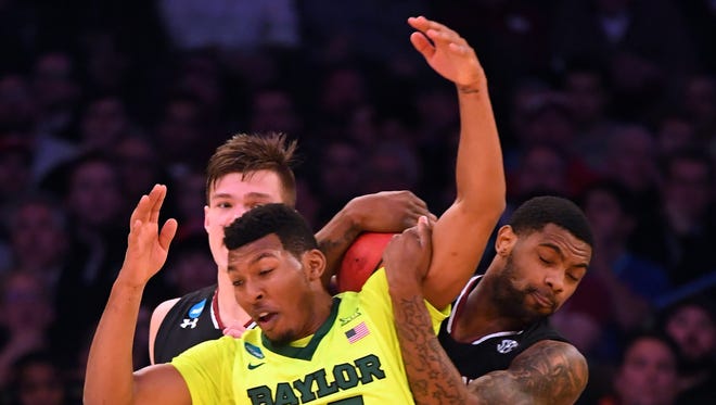 Baylor guard King McClure (22) and South Carolina guard Sindarius Thornwell, right, go for a loose ball during the second half of their game in the Sweet 16 of the NCAA tournament at Madison Square Garden in New York.