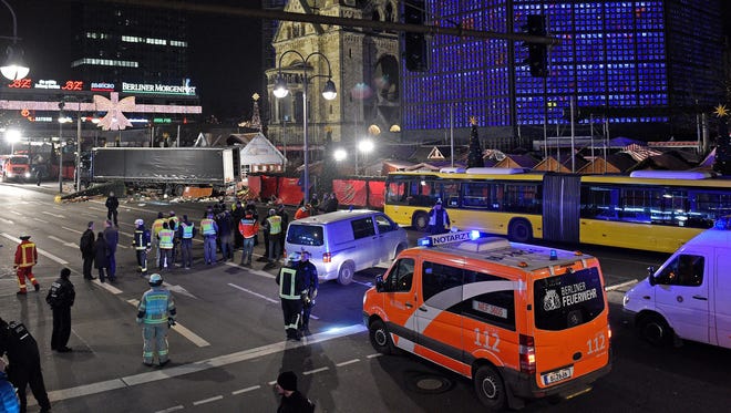 Police and rescue workers secure the site next to a truck at the scene, after it crashed into a Christmas market in Berlin, Germany on Dec. 19, 2016.