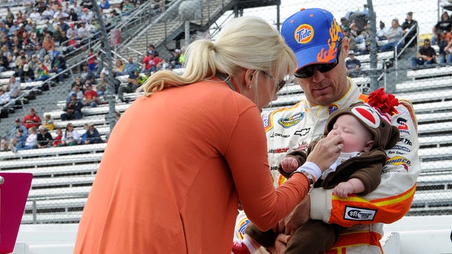 Kevin Harvick holds his son, Keelan, as his wife, DeLana, tends to him on the grid during pre-race ceremonies for the NASCAR Camping World Truck Series Kroger 200 at Martinsville Speedway on October 27, 2012.