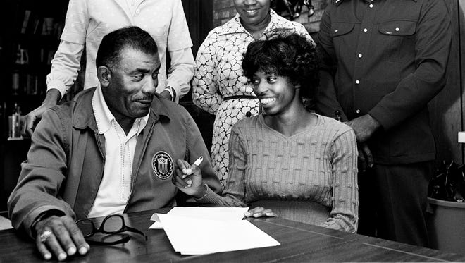 North High track star Teresa Bough, sitting right, puts her signature on a grant-in-aid under the watchful eye of Tennessee State Tigerbelle coach Ed Temple May 3, 1975. Watching is North girls' track coach Blanche Stevens, left, and Pauline and Ernest Bough, Teresa's parents.