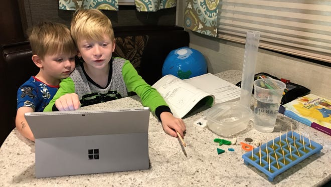 Kindergartner Tristan Logue, 6, logs onto his virtual school while on a yearlong, cross-country trip. His brother Jasper, 3, follows along.