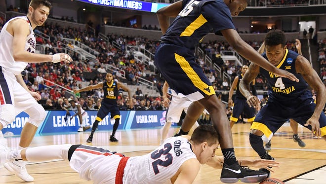 Gonzaga Bulldogs forward Zach Collins (32) goes after the ball with West Virginia Mountaineers forward Elijah Macon (45) and guard Daxter Miles Jr. (4) during the first half in the semifinals of the West Regional of the 2017 NCAA Tournament at SAP Center.