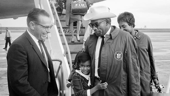 Paul Startup, left, representative of Mayor Beverly Briley, looks on as Tennessee A&I State University coach Ed Temple is greeted by his daughter, Edwina, after he and Tigerbelles sprinters Wyomia Tyus and Edith McGuire walk off the plane after arriving from the Tokyo Olympics at Nashville Municipal Airport Oct. 28, 1964.