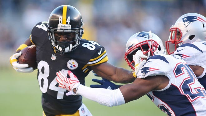 Steelers wide receiver Antonio Brown (84) stiff-arms Patriots cornerback Logan Ryan (26) during the second quarter.