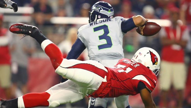 Seahawks quarterback Russell Wilson (3) is pressured by Cardinals linebacker Kevin Minter (51) in the first quarter.