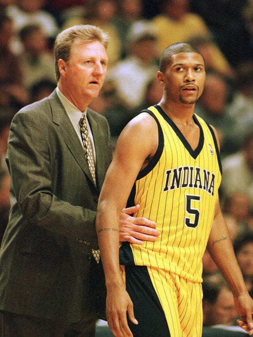 Indiana Pacers coach Larry Bird, left, talks with Pacers guard Jalen Rose as they play the Washington Wizards in the season opening game in Indianapolis, Feb. 5, 1999.
