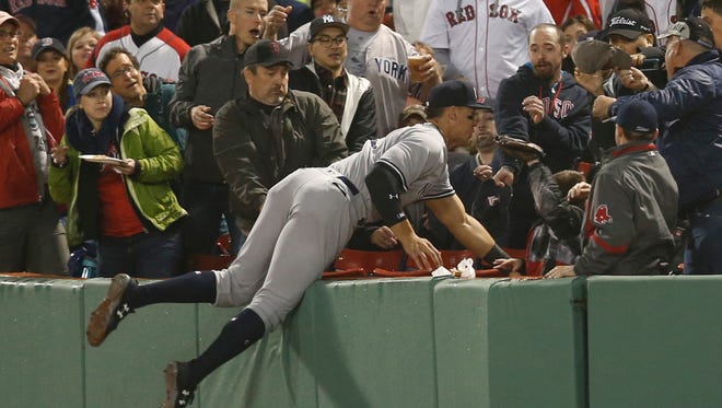April 26: Aaron Judge dives into the stands to catch a fly ball hit by Red Sox's Xander Bogaerts.