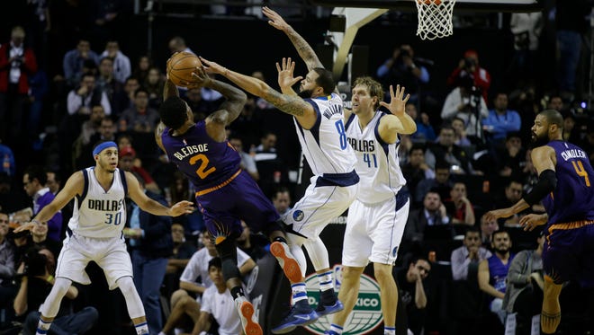 Phoenix Suns Eric Bledsoe tries to shoot over Dallas Mavericks Deron Williams (8), and Dallas Mavericks Dirk Nowitzki (41) in the first half of their regular-season NBA basketball game in Mexico City, Thursday, Jan. 12, 2017. At left is Dallas Mavericks Seth Curry and at right is Phoenix Suns Tyson Chandler.