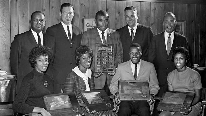 Tennessee State University Olympians and coach Ed Temple, back center, hold plaques presented to them by Gulf Oil Company at a luncheon Nov. 24, 1964. At the event are Olympians Vivian Brown, front left, Edith McGuire, Ralph Boston and Wyomia Tyus; Dr. W.S. Davis, back left, A&I president; Wise Crunk of Gulf Oil; Coach Temple; George Farras of Gulf Oil; and Dan Kean, public relations man for Gulf Oil.