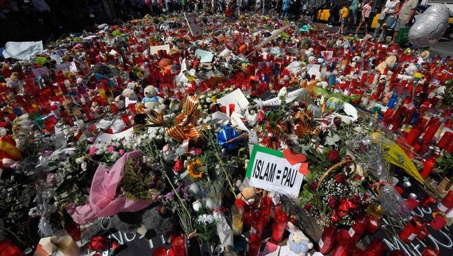 People display flowers and candles to pay tribute to the victims of the Barcelona and Cambrils attacks on the Rambla boulevard in Barcelona on Aug. 22, 2017, five days after the attacks that killed 15 people. An alleged member of the terror cell that unleashed carnage in Spain last week admitted to a judge Tuesday that he and other suspects had planned a bigger attack, a judicial source said.