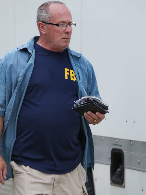 An FBI agent delivers a handful of media storage disks taken from the Zionsville home of Subway spokesperson Jared Fogle to an evidence truck parked in Fogle's driveway in the 4500 block of Woods Edge Drive in the Austin Oaks subdivision on Tuesday morning, July 7, 2015. The FBI, U.S. Postal Inspection Service Police and Indiana State Police conducted a raid during a criminal investigation. Multiple computer devices and disks were taken from the home to the truck for inspection and were reviewed while Fogle was present in the truck with them.