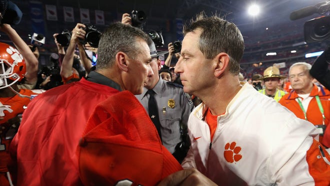 Clemson's Dabo Swinney right greets Ohio State's Urban Meyer at midfield after the game.