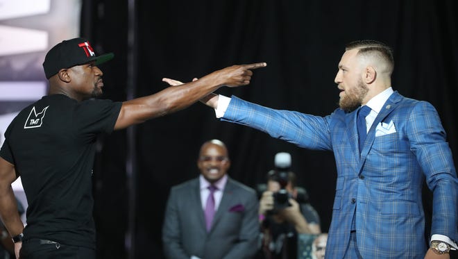 Floyd Mayweather and Conor McGregor point and stare down each other during a world tour press conference to promote the upcoming Mayweather vs McGregor boxing match.