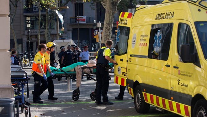 Mossos d'Esquadra Police officers and emergency service workers move an injured person after a van crashes into pedestrians in Las Ramblas, downtown Barcelona, Spain, on Aug. 17, 2017. According to initial reports a van crashed into a crowd in Barcelona's famous Placa Catalunya square at Las Ramblas area injuring several. Local media report the van driver ran away, metro and train stations were closed. The number of people injured and the reasons behind the incident are not yet known.