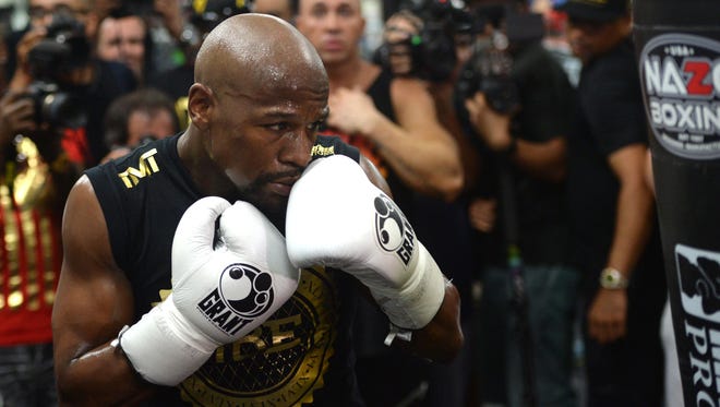 Floyd Mayweather Jr. hits a heavy bag during a media workout in preparation for his fight against Conor McGregor at Mayweather Boxing Club.