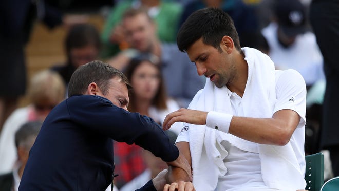 Novak Djokovic is given treatment before retiring his quarterfinal match against Tomas Berdych on day nine.