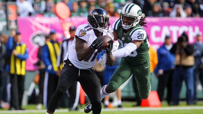 Baltimore Ravens wide receiver Kamar Aiken (11) catches a pass while being defended by New York Jets cornerback Marcus Williams (20) during the first half at MetLife Stadium.