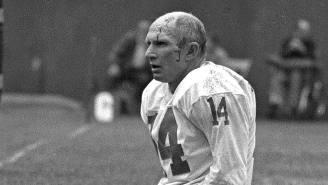** FILE ** New York Giants quarterback Y.A. Tittle squats on the field after being shaken up during a game against the Pittsburgh Steelers, Sept. 20, 1964.  The New York Giants quarterback was hit hard while passing and was intercepted by Steelers tackle Chuck Hinton, who ran the ball back for a touchdown. To an earlier generation, this single black-and-white photo fixed what the game was about: Y.A. Tittle on his knees, a trickle of blood creasing his bald pate.
