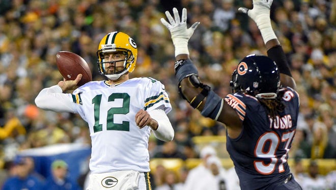 Green Bay Packers quarterback Aaron Rodgers (12) throws a pass while under pressure from Chicago Bears linebacker Willie Young (97) in the first quarter at Lambeau Field.
