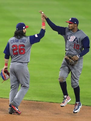 United States outfielder Adam Jones and teammate Brandon Crawford celebrate after defeating Japan in the semifinal of the World Baseball Classic at Dodger Stadium.