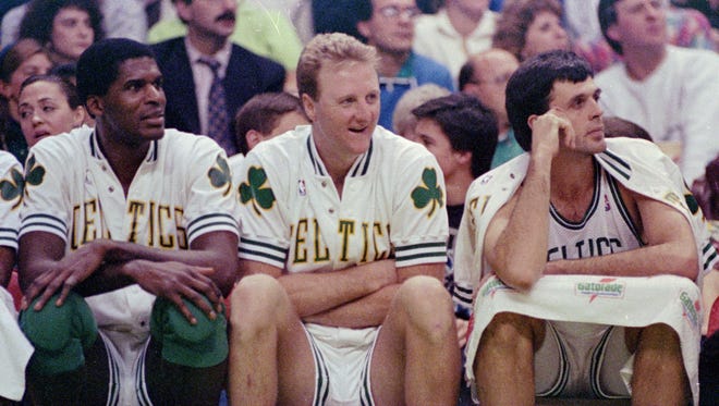 This is a November 1991 file photo showing former Boston Celtics stars Robert Parish, left, Larry Bird and Kevin McHale, right, together on the bench during a game at the Boston Garden in Boston.