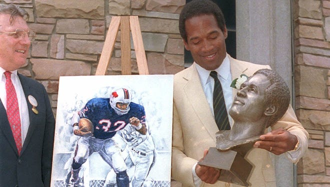 Simpson checks out the bronze bust of himself after his induction into the Pro Football Hall of Fame in 1985.