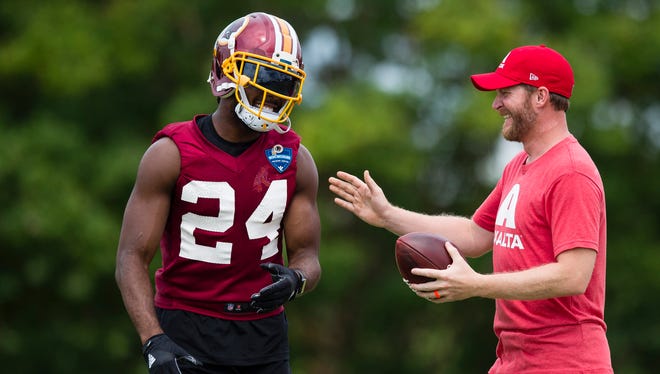 Dale Earnhardt Jr., driver of the No. 88 Axalta Chevrolet SS, talks with Washington Redskins cornerback Josh Norman (24) after catching a pass after practice during Redskins training camp at Bon Secours Washington Training Center.