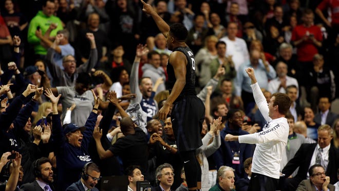 Xavier's Tyrique Jones jumps onto the scorer's table to celebrate a win over Arizona in the Sweet 16.