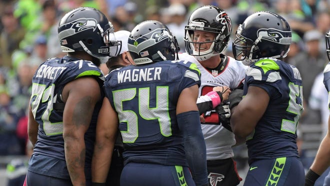 Falcons quarterback Matt Ryan (2) argues with Seahawks players Michael Bennett, Bobby Wagner and Cliff Avril.