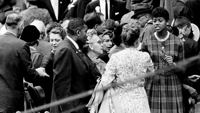 Wilma Rudolph, right, winner of three gold medals at the recent Olympics, is being greeted by a fan after Vice President Richard Nixon's speech at the Memorial Square in Nashville. Tennessee State track coach Ed Temple, center, and other gold medal winners from the school were seated on the platform Oct. 6, 1960.