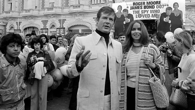 Roger Moore, alias British secret agent James Bond, is accompanied by co-star Barbara Bach as they arrive for the screening of their latest 007 feature, "The Spy Who Loved Me,"  May 20, 1977.