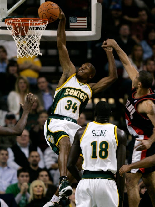 Ray Allen dunks the ball as Portland Trail Blazers' Ime Udoka and Sonics center Mouhamed Sene look on.