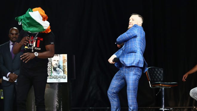 Conor McGregor throws an Irish flag at Floyd Mayweather as he speaks during a world tour press conference to promote the upcoming Mayweather vs McGregor boxing match.