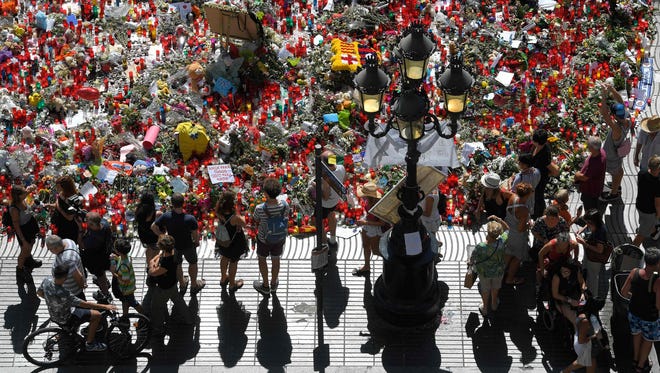 People display flowers and candles to pay tribute to the victims of the Barcelona and Cambrils attacks on the Rambla boulevard in Barcelona on Aug. 22, 2017, five days after the attacks that killed 15 people.