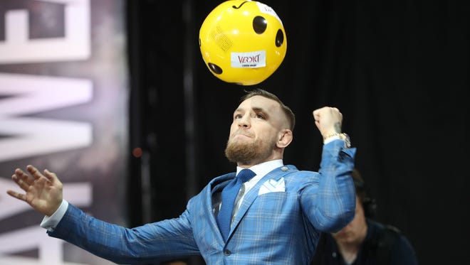Conor McGregor punches a beach ball that made its way onto the stage during a world tour press conference to promote the upcoming Mayweather vs McGregor boxing match.