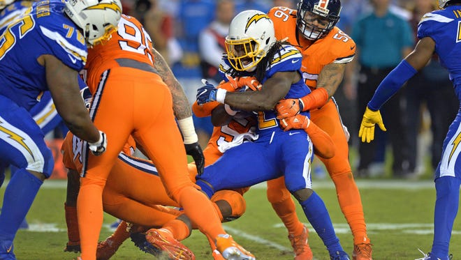 San Diego Chargers running back Melvin Gordon (28) is stopped by Denver Broncos outside linebacker Von Miller (58) and outside linebacker Shane Ray (56) during the second quarter at Qualcomm Stadium.