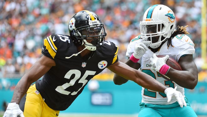 Miami Dolphins running back Jay Ajayi (23) runs the ball against Pittsburgh Steelers cornerback Artie Burns (25) during the first half at Hard Rock Stadium.