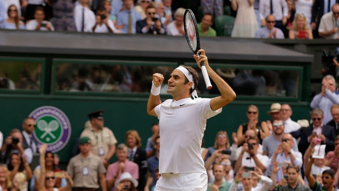 Roger Federer puts his arms up after clinching the title.